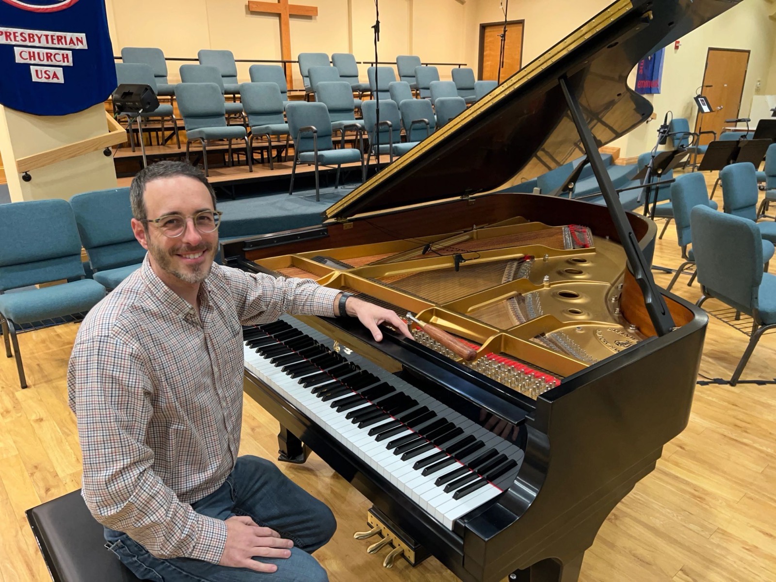 Philip Smith seated at a grand piano in a church sanctuary
