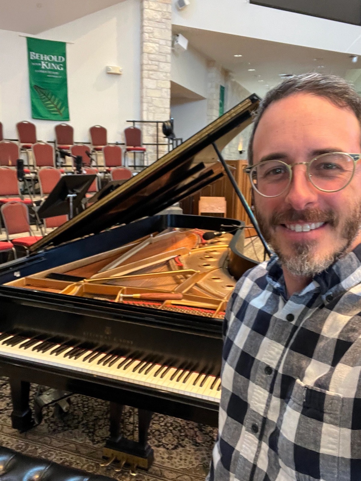 Philip Smith beside a grand piano he has just tuned